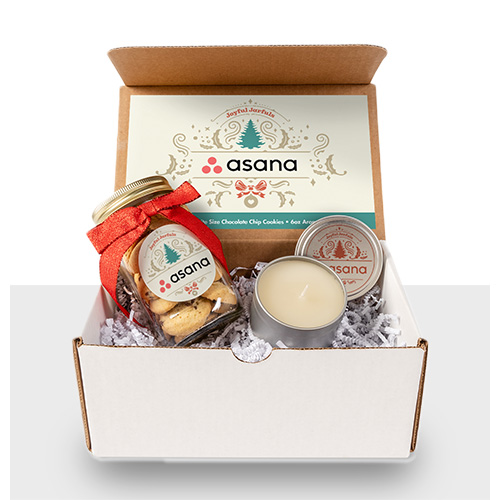 White mailer box gift set containing a glass jar of cookies, a candle, and a full color printed insert card